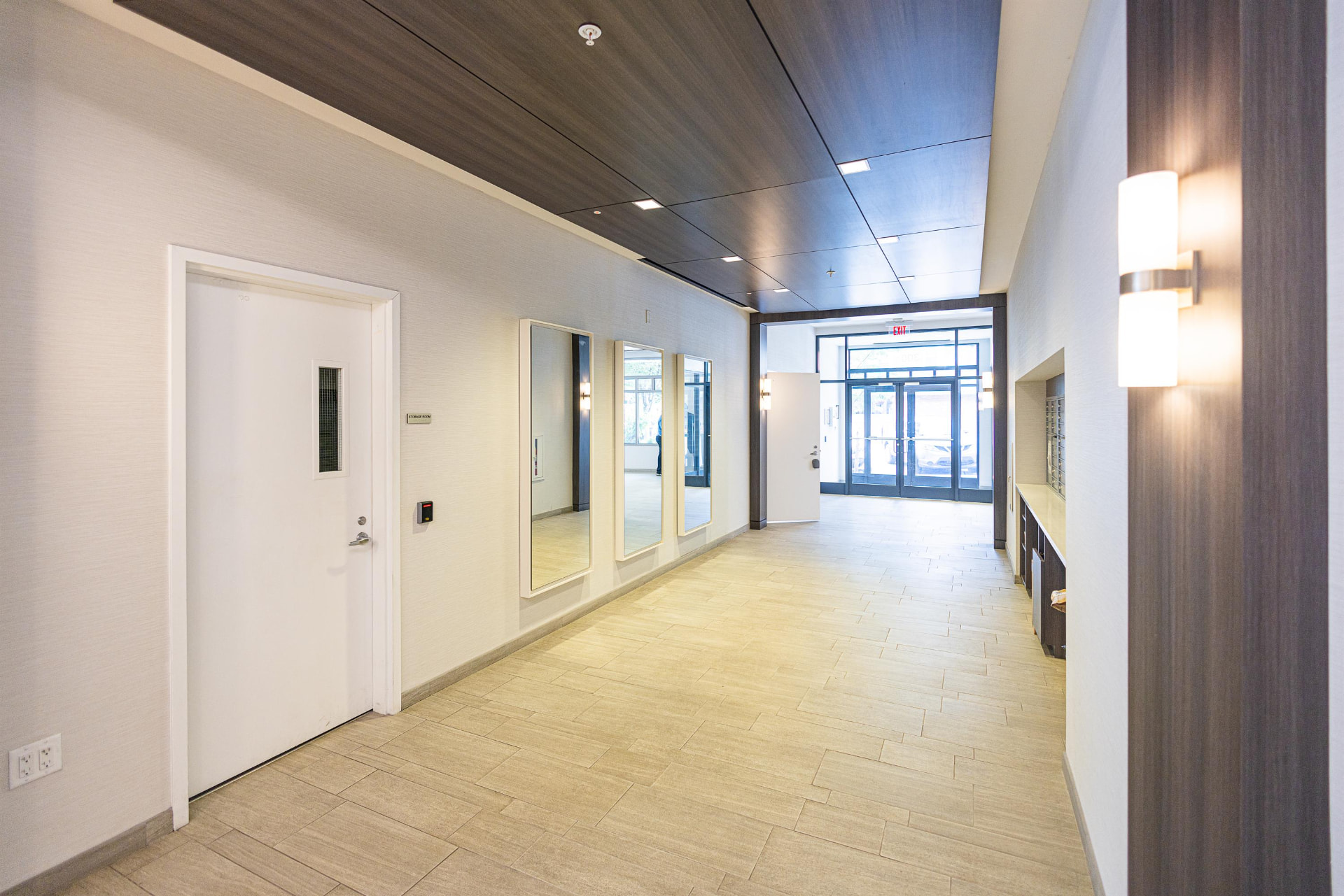 Lobby corridor with walnut ceiling, mirrors and resident mailboxes