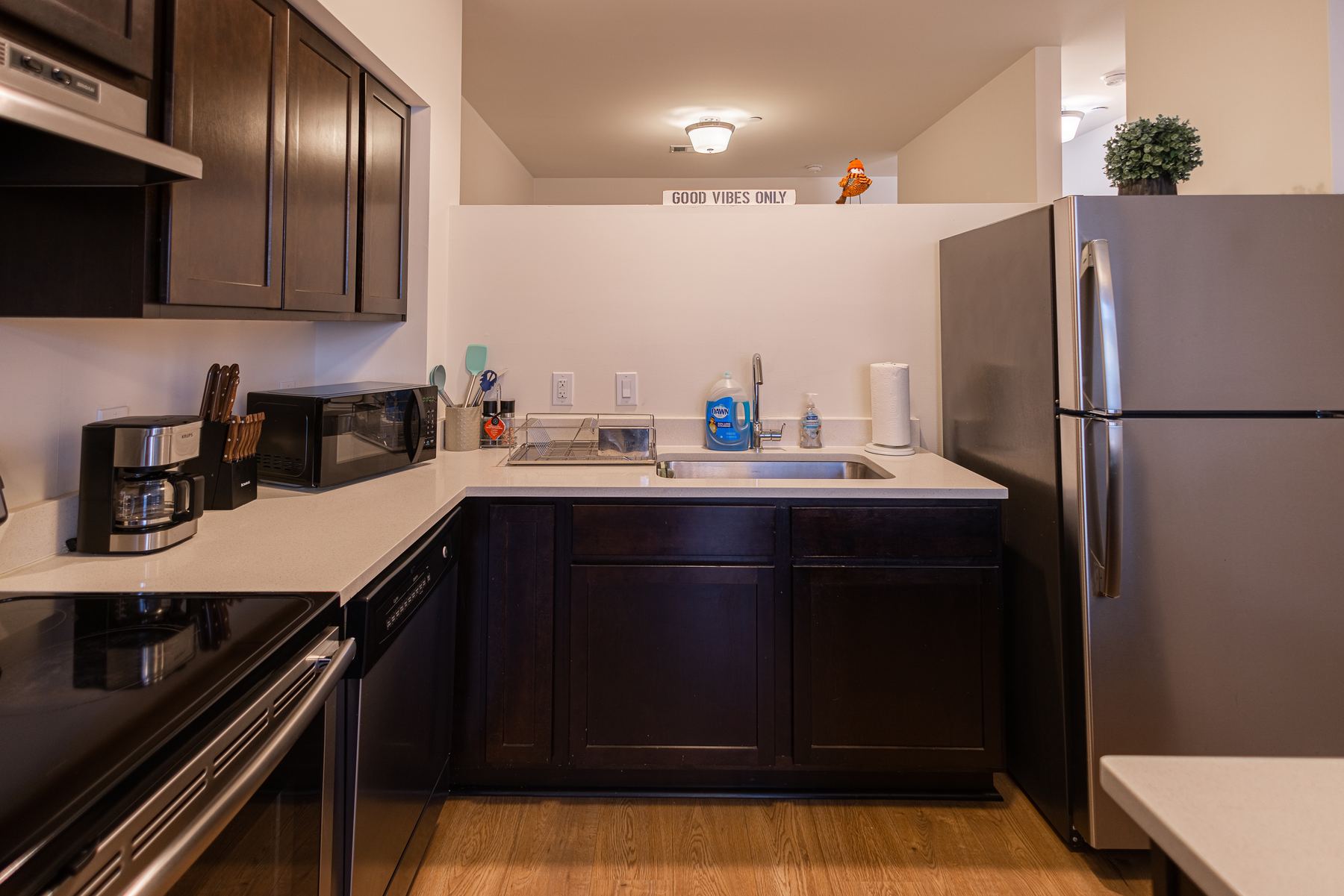 Kitchen with dark cabinetry and stainless steel appliances