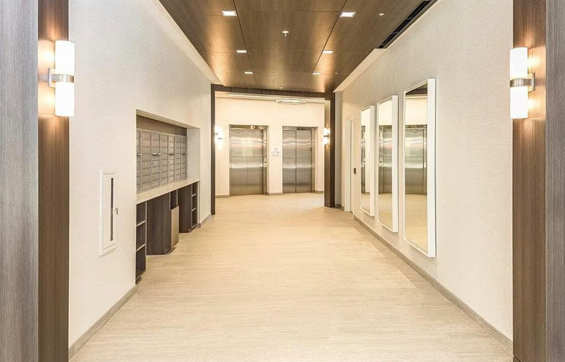 Lobby mailroom corridor with resident mailboxes, mirrors and elevators