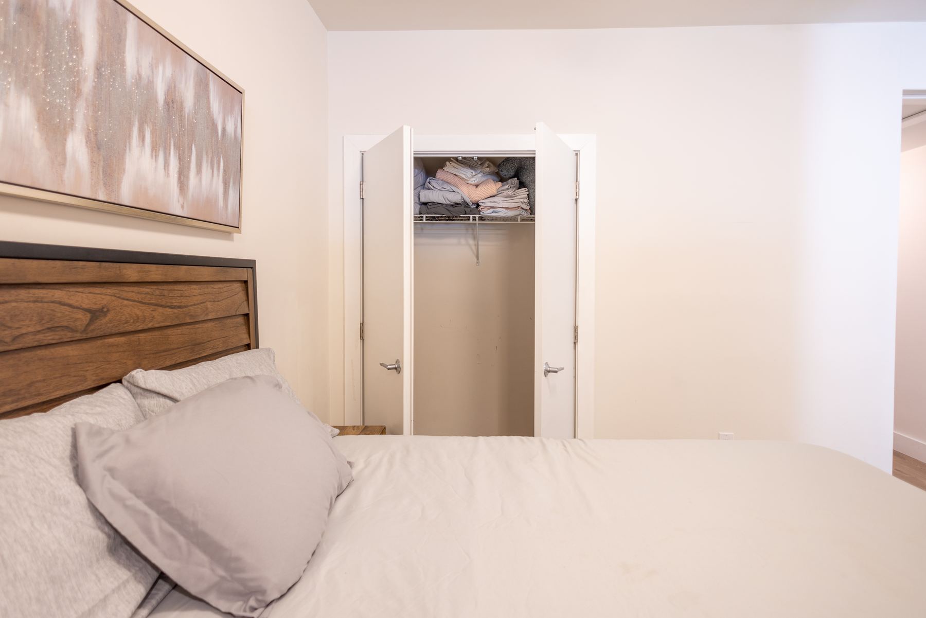 Bedroom with wood headboard and closet