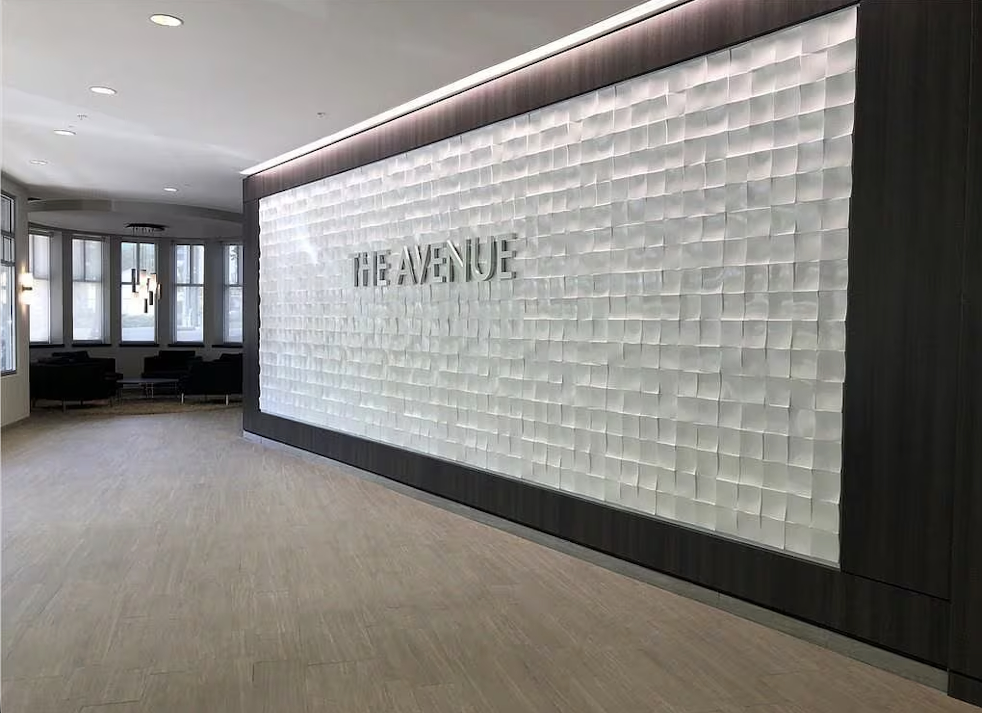 Lobby signature wall with backlit textured panels and The Avenue lettering