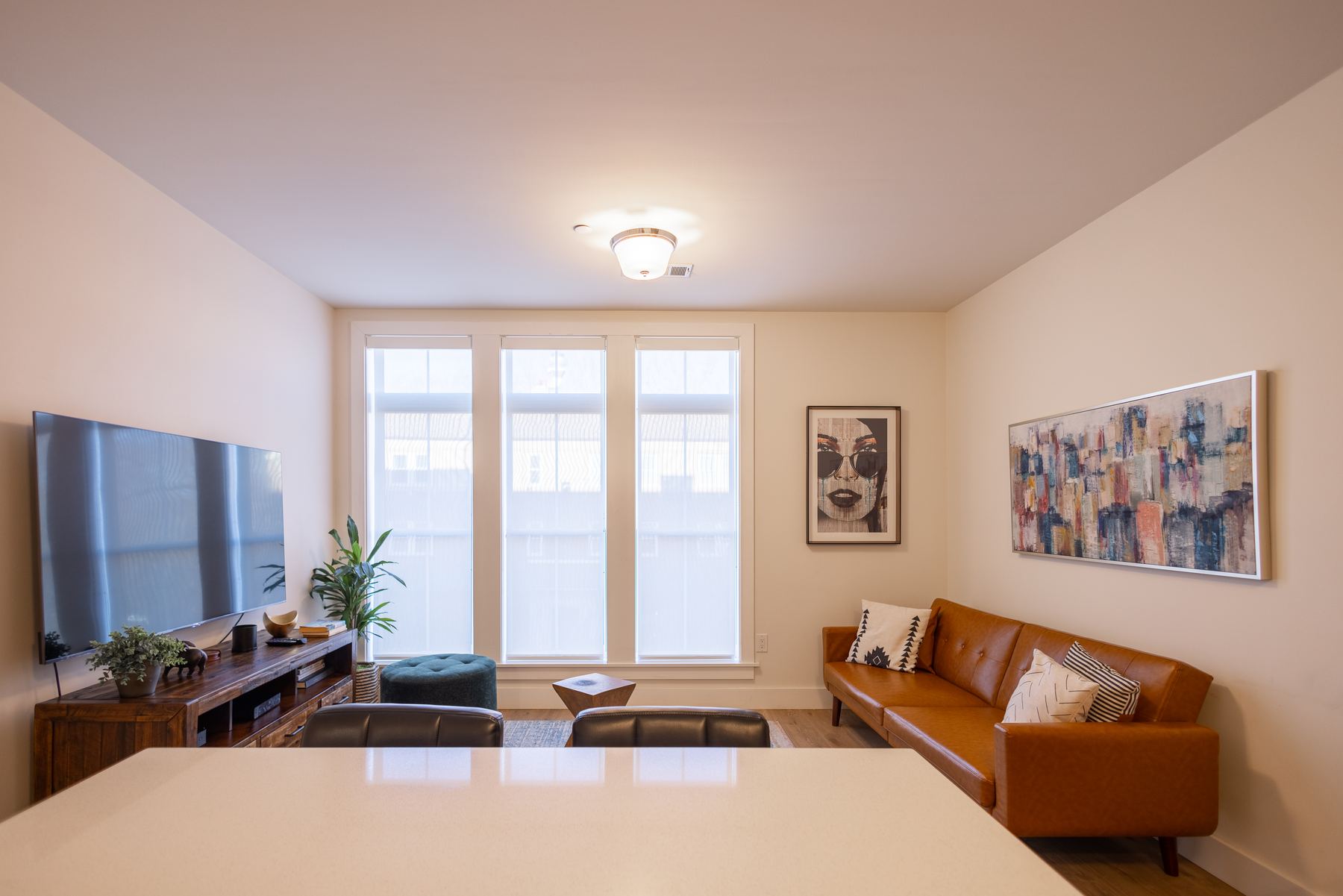 Staged living room with hardwood floors and oversized windows