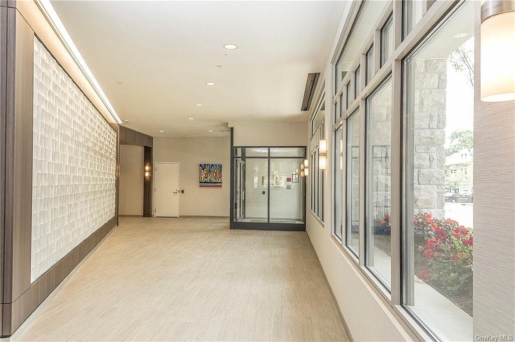 Sunlit lobby entrance with textured stone wall at The Avenue at Crestwood