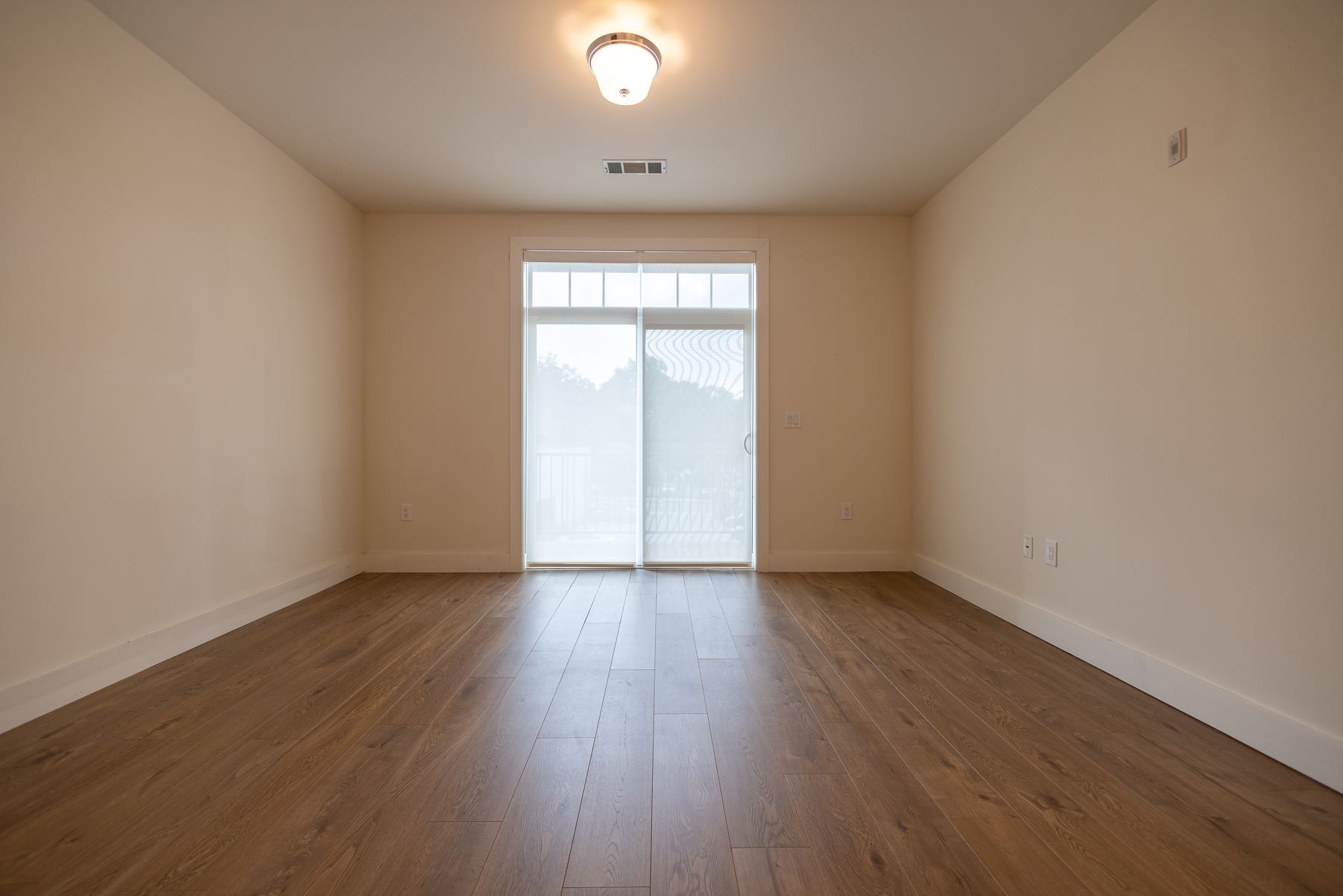 Empty open living space with wide-plank flooring