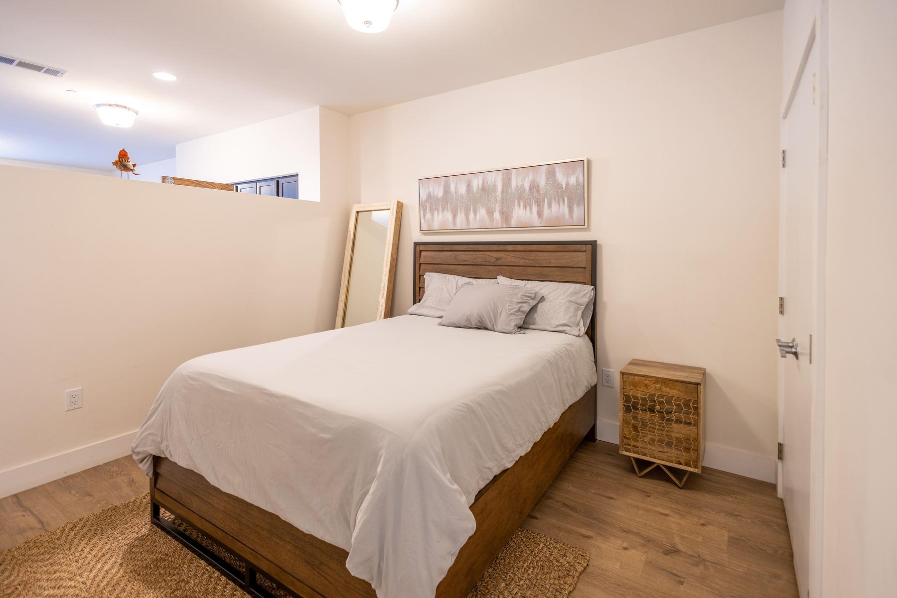 Furnished bedroom with upholstered bed and natural light